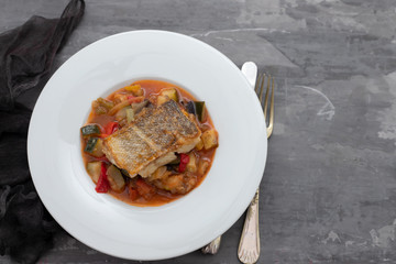 cod fish with vegetables in white plate