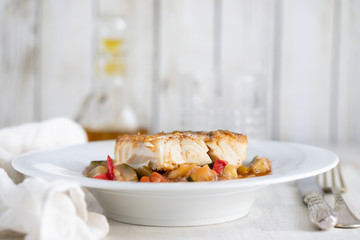 cod fish with vegetables in white plate