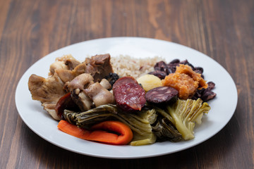 typical portuguese dish boiled meat, smoked sausages, vegetables and rice on white plate