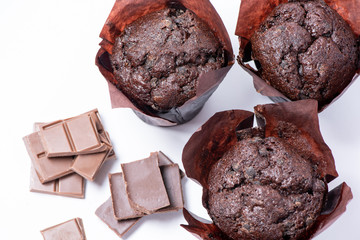 Delicious muffins with slices of chocolate isolated on white background