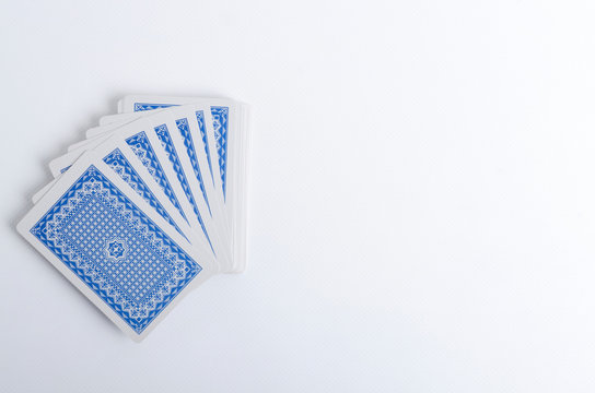 Top vieц of deck of plaing cards on the white surface.Empty space for text