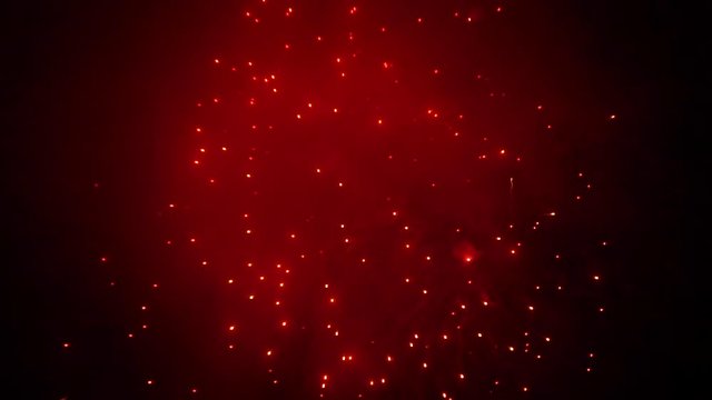 Beautiful Red Colored Sparks from Fireworks in the Night Sky. The Concepts of Festivals, Holidays and City Celebrations