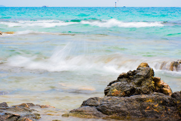 The rocks on the beach and the incoming sea water. And the sea and sky background