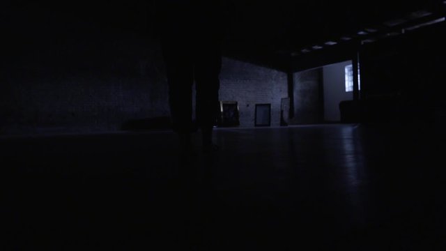 silhouette in dark room walking towards mirrors