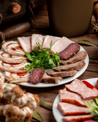 plate with sliced ham and sausages