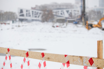 The road repair and caution fenced white red ribbon, everything is covered the snow.