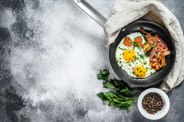 Fried eggs with bacon in a pan. Keto Diet. Keto breakfast. Low carb diet concept. high fat diet. Gray background. Top view. Space for text
