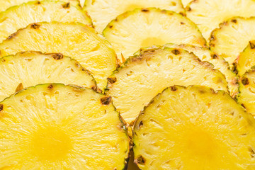 Pineapple juicy yellow slices background. Top view.