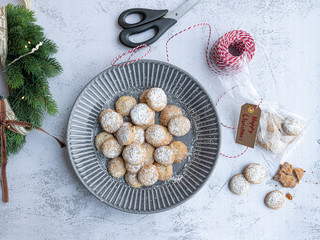 christmas cookies in a grey ceramic bowl sprinkled with icing sugar, making christmas diy gifts, wreath decoration on the table
