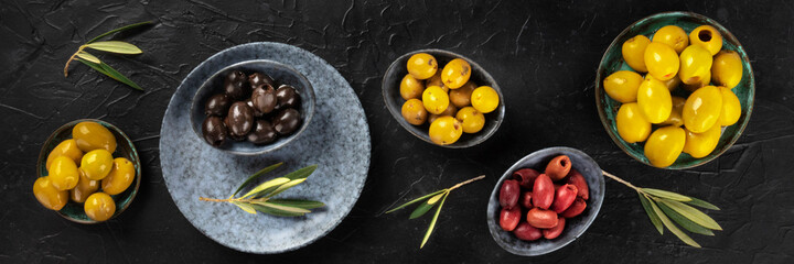 Olives variety panorama, an overhead flat lay shot on a dark background