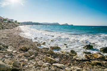 Ionic sea braking against stones and pebbles on a beach