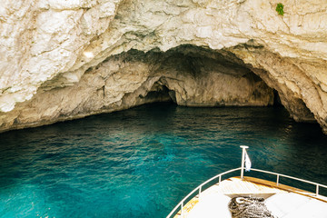 Greece 2018, Greek boat approaching giant caves in the cliffs