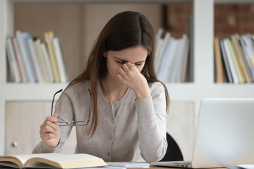 Overload young girl feeling fatigue, taking off glasses.