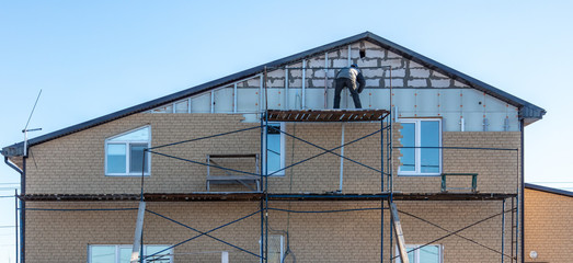 Naklejka premium Installation of siding on the walls of the house