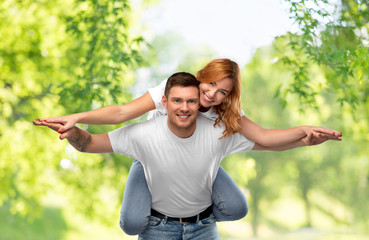 relationships and people concept - portrait of happy couple in white t-shirts having fun over green natural background