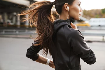 Poster Strong fitness woman running outdoors by street. © Drobot Dean