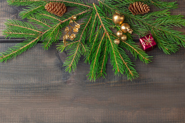 Christmas composition. Frame of the fir branches and balls on a dark rustic wooden background. Christmas, winter holidays, new year concept. Top view, flat lay, copy space for text.