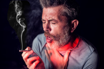 Man smokes cigarette and has problem with lungs. Cigarette addiction concept