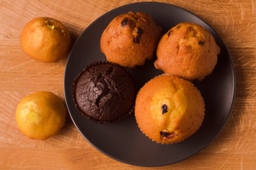 Appetizing muffins (muffins) on a black dish and wooden plate