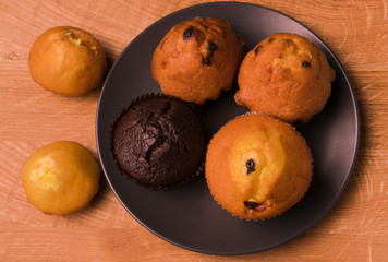 Appetizing muffins (muffins) on a black dish and wooden plate