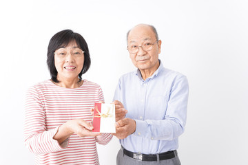 お祝いを渡すシニアの夫婦
