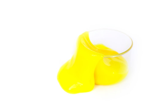 Toy called slime spilling from the jar. Transparent yellow mucus isolated on a white background. Selective focus