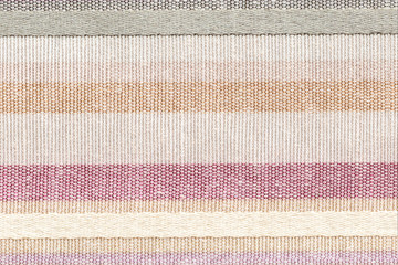 Rustic canvas fabric texture. Colored striped coarse linen fabric closeup as pattern background.