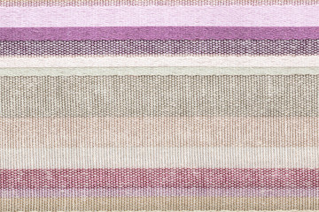 Colored striped coarse linen fabric closeup as pattern background. Rustic canvas fabric texture.