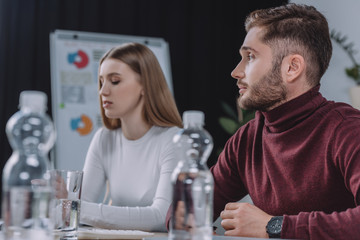 selective focus of young businesspeople sitting in meeting room