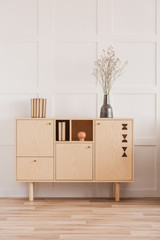 Dry flowers in vase on wooden commode in classy daily room