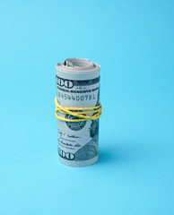 rolled up and connected rubber band banknotes of american dollars