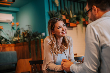 Cute young woman with her boyfriend at the cafe.
