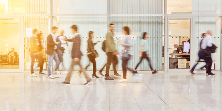 Anonymous people go through hall in office