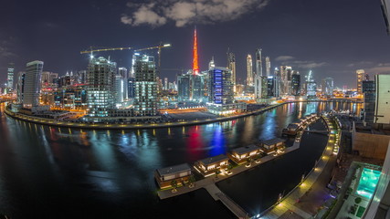 Night city Dubai near canal with bright skyscrapers aerial timelapse