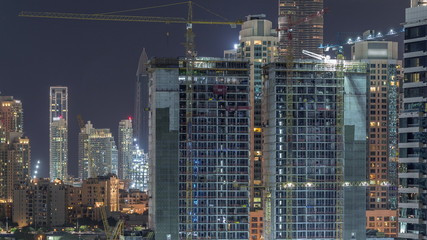 Aerial view of constructing with cranes night timelapse in Dubai.