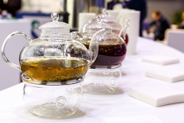 Transparent glass teapot with tea leaves