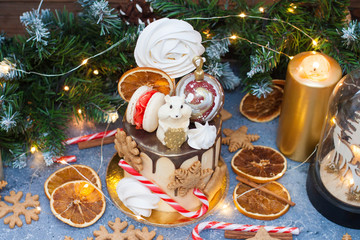 New Year cake with chocolate mouse, meringue, macaroons, candy cane, gingerbread cookies and dried oranges. 