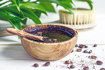 Coffee peeling .Coffee grounds scrub handwork in a wood bowl on a light wooden table. Natural body cosmetics. Body care with natural remedies. Top View Copy Space