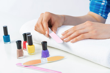 Obraz na płótnie Canvas Woman using nail file and create nails shape