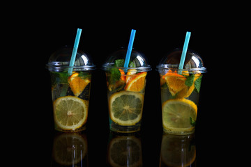 Three glasses of lemonade isolated on a black background.