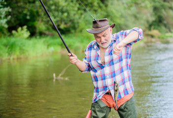 Fisherman fishing equipment. Fisherman alone stand in river water. Hobby sport activity. Fish farming pisciculture raising fish commercially. Pensioner leisure. Man senior bearded fisherman