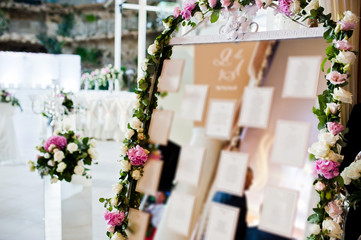 Fototapeta premium Beautiful wedding set decoration in the restaurant. Board with guest list