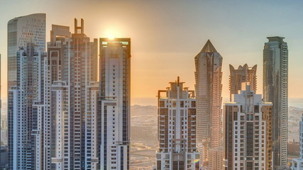 Modern residential and office complex with many towers aerial timelapse at sunset in Business Bay, Dubai, UAE.