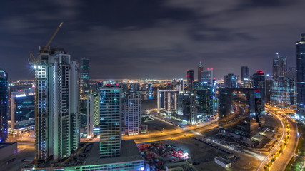 Naklejka premium Aerial view of illuminated buildings and high traffic in modern Dubai city, United Arab Emirates Timelapse Aerial