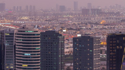 Dubai's business bay towers at evening aerial day to night timelapse.