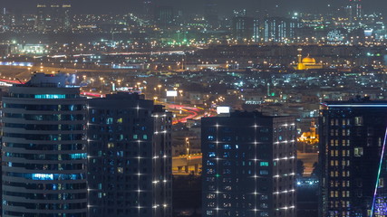 Fototapeta na wymiar View of bright lights on tall skyscrapers near highways in Dubai city, United Arab Emirates Timelapse Aerial