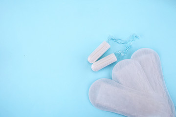 Menstrual tampons and pads on a blue background. Menstruation time. Hygiene and protection