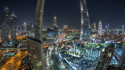Fototapeta premium Panoramic skyline view of Dubai downtown with mall, fountains and skyscrapers aerial night timelapse