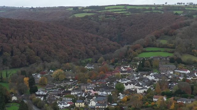 Wide aerial orbit of Dulverton, located on the River Barle on the edge of Exmoor, UK. Drone shot looking across the valley.