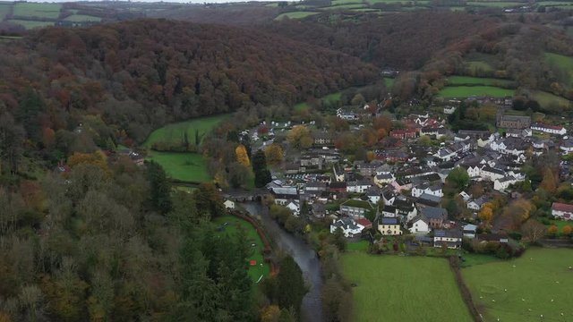 Wide aerial dolly shot pushing down the River Barle in Dulverton, a small market town on the edge of Exmoor, UK.